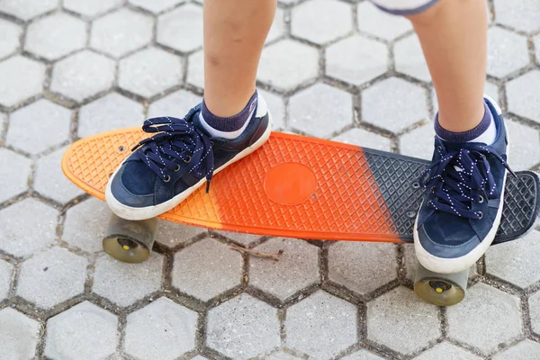 Rapaz urbano com um skate de um centavo. Jovem criança equitação em th — Fotografia de Stock