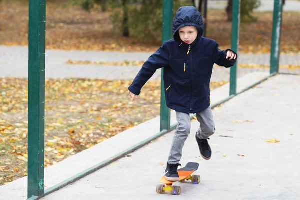 Маленький міський хлопчик з копійки скейтборд. Дитяче ковзання в авто — стокове фото