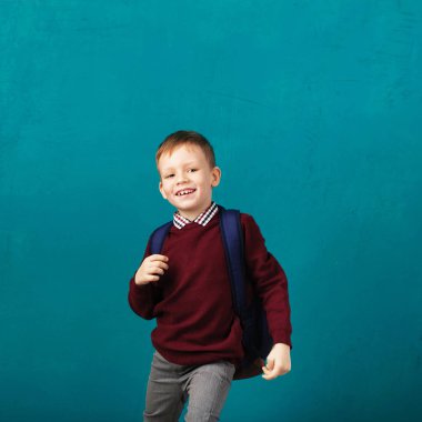 Neşeli gülümseyen küçük çocuk ile atlama ve sahip büyük sırt çantası