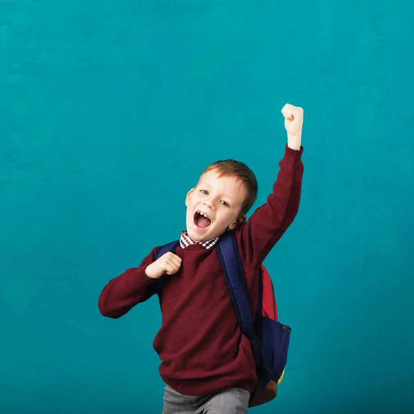 Alegre sorrindo menino com grande mochila pulando e ter — Fotografia de Stock