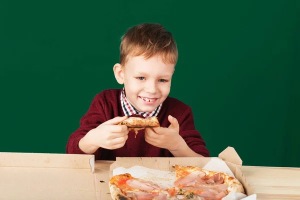 I bambini mangiano pizza italiana nel caffè. Scuola ragazzo sta mangiando piz — Foto Stock