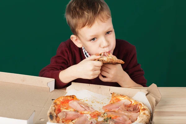 I bambini mangiano pizza italiana nel caffè. Scuola ragazzo sta mangiando piz — Foto Stock