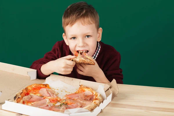 Ребенок ест пиццу из коробки крупным планом фото — стоковое фото
