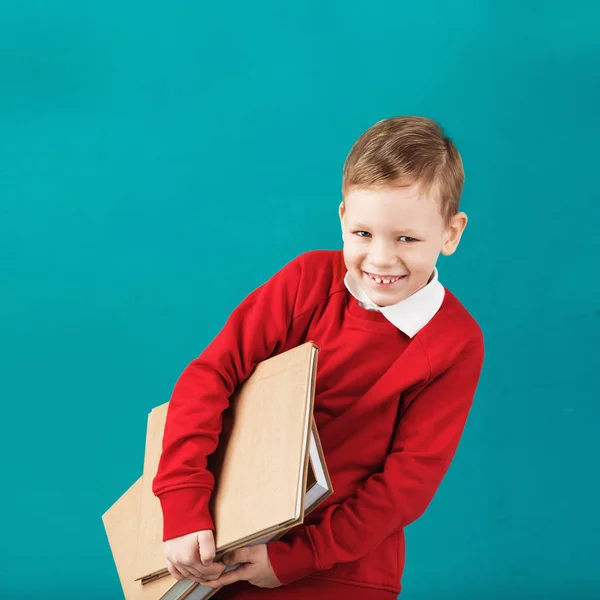 Glada leende liten pojke med stora böcker — Stockfoto