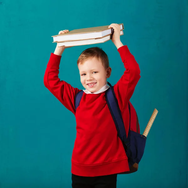 Wesoły zadumany mały chłopiec szkoły w mundurki z bac — Zdjęcie stockowe