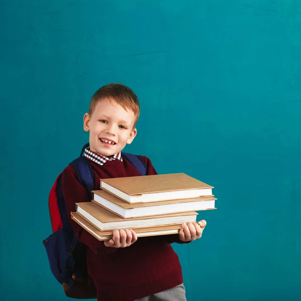 Веселый вдумчивый школьник в школьной форме с баком. — стоковое фото