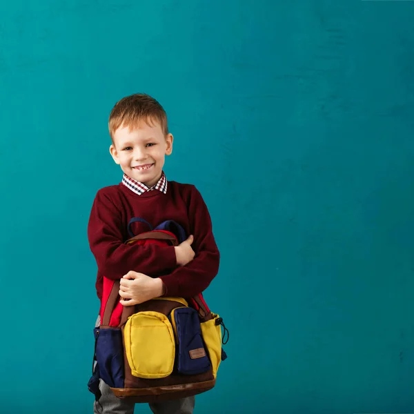 Cheerful thoughtful little school boy in school uniform with big — Stock Photo, Image