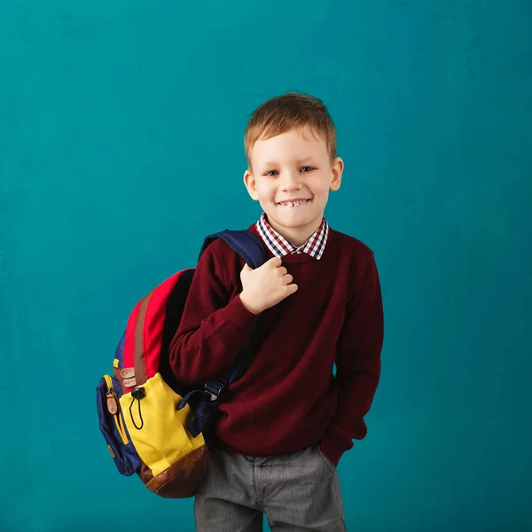 Cheerful thoughtful little school boy in school uniform with big — Stock Photo, Image