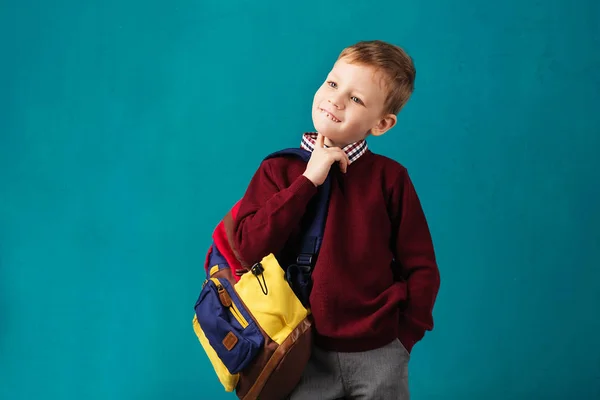 Cheerful thoughtful little school boy in school uniform with big — Stock Photo, Image