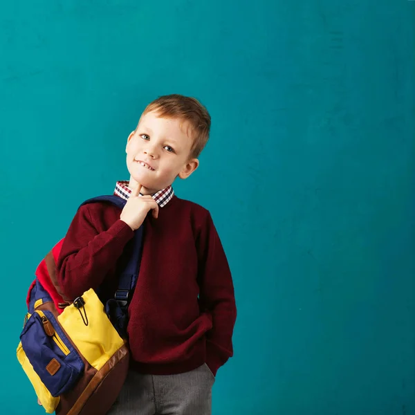 Cheerful thoughtful little school boy in school uniform with big — Stock Photo, Image