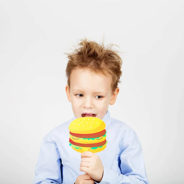 Carino poco scuola ragazzo con falso carta hamburger contro un bianco ba — Foto Stock