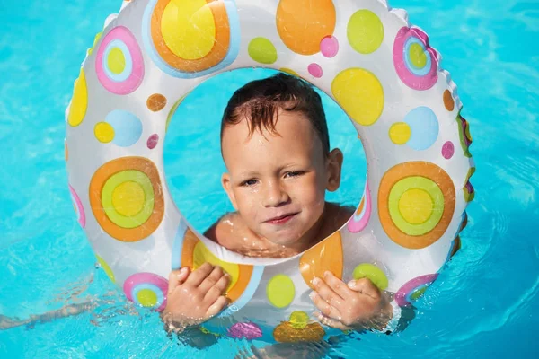 Niño feliz jugando en el agua azul de la piscina. Pequeño chico lea — Foto de Stock