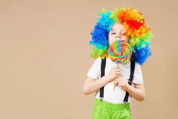 Felice clown ragazzo in grande parrucca colorata. Festeggiamo! Ragazzo divertente cl — Foto Stock