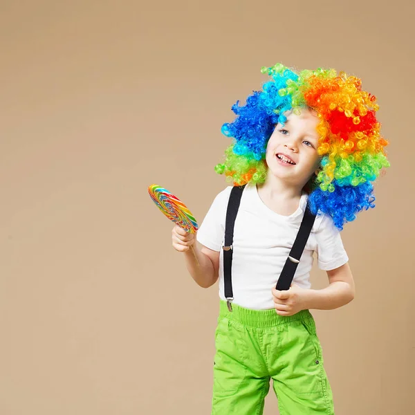 Felice clown ragazzo in grande parrucca colorata. Festeggiamo! Ragazzo divertente cl — Foto Stock