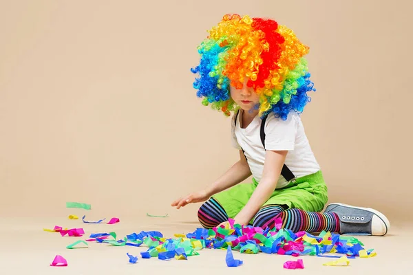 Happy clown boy with large colorful wig. Let\'s party! Funny kid