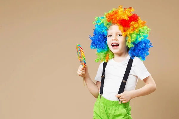 Fröhlicher Clownsjunge in großer bunter Perücke. Lasst uns feiern! Lustiges Kind — Stockfoto