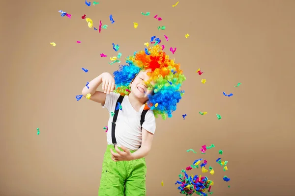 Felice clown ragazzo con grande parrucca colorata. Festeggiamo! Ragazzo divertente — Foto Stock