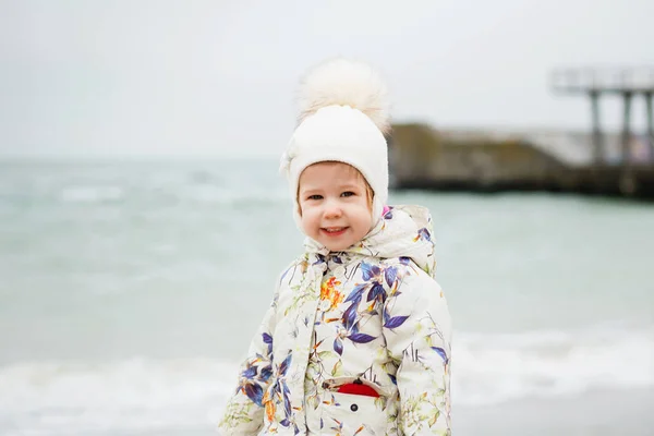 Linda niña jugando en la playa de arena. Niño feliz usando —  Fotos de Stock