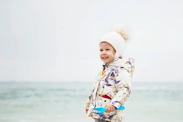 Linda niña jugando en la playa de arena. Niño feliz usando —  Fotos de Stock