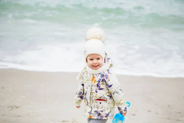 Linda niña jugando en la playa de arena. Niño feliz usando —  Fotos de Stock