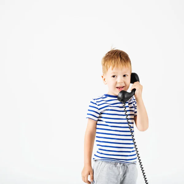 Little boy with retro phone against a white — Stock Photo, Image