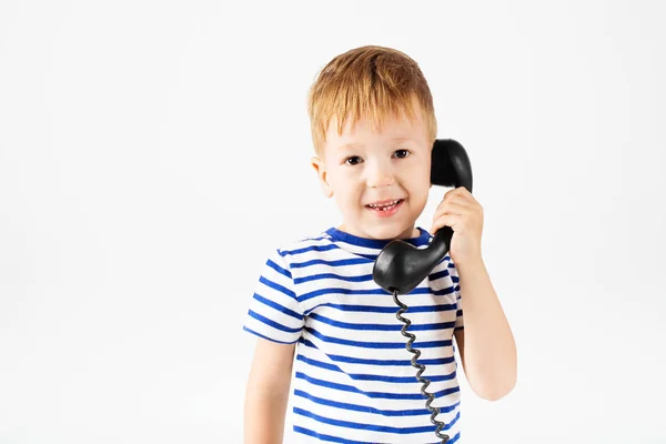 Jongetje met retro telefoon tegen een wit — Stockfoto