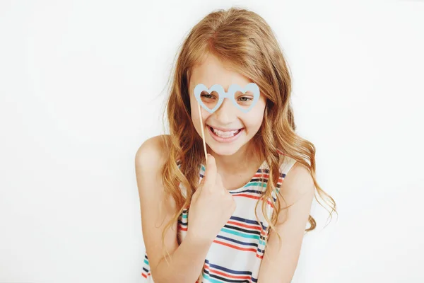 Encantadora niña con divertido partido de papel corazón forma gafas o — Foto de Stock