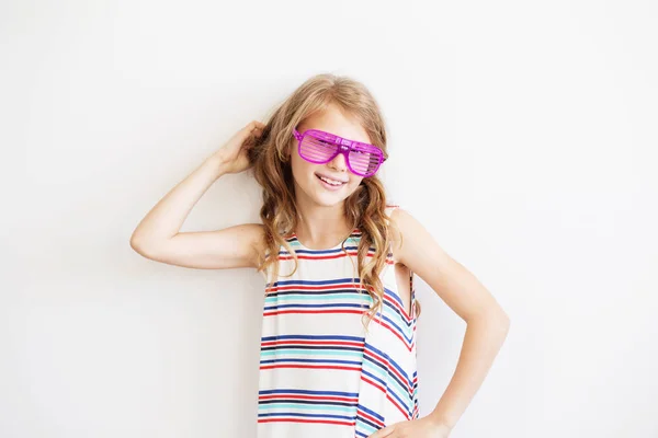 Krásná holčička v pruhované šaty s legrační strana plastové s — Stock fotografie
