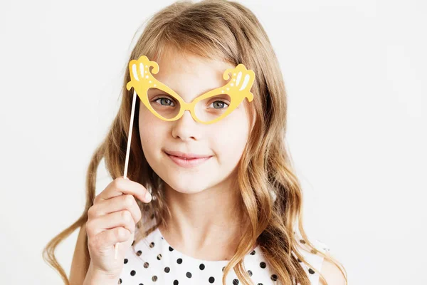 Retrato de una niña encantadora con gafas de papel de fiesta divertidas — Foto de Stock