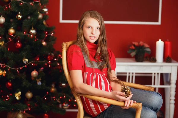 Ganska leende tonåring flicka med långt hår i interiör med julstämning — Stockfoto