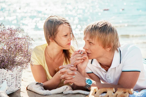 Счастливая молодая пара наслаждается пикником на пляже и хорошо провести время — стоковое фото