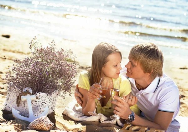Счастливая молодая пара наслаждается пикником на пляже и хорошо провести время — стоковое фото