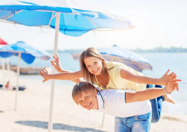 Young couple in love having fun and jumping on the beach — Stock Photo, Image