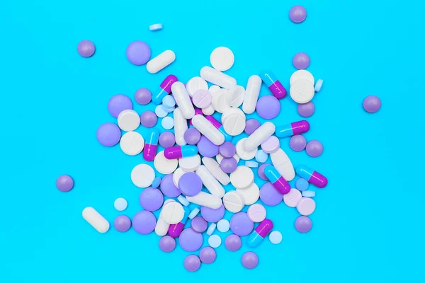 Drugs capsules and pills on blue background. — Stock Photo, Image