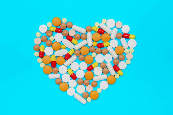 Comprimidos multicoloridos dispostos na forma do coração . — Fotografia de Stock