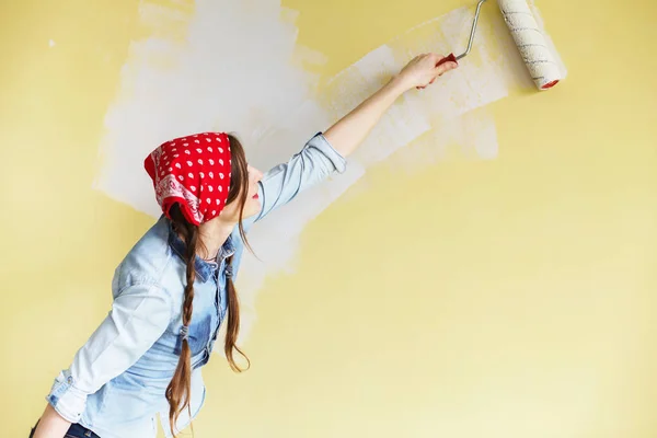 Hermosa chica en rojo Diadema pintura de la pared con rollo de pintura —  Fotos de Stock