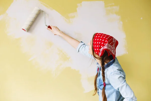 Retrato de una joven mujer hermosa pintando la pared en su nueva apa —  Fotos de Stock