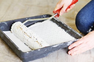 Dairenin duvarını kadın alçı ustası boyuyor. Tepsi
