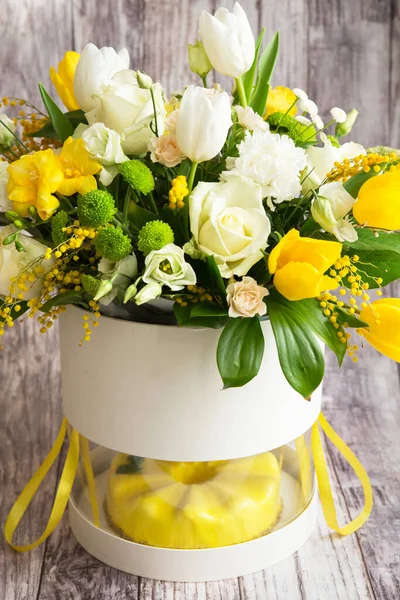 Gift set - yellow mousse cake and a large Spring medley bouquet of beautiful flowers. Valentine\'s Day. Happy Mother\'s day