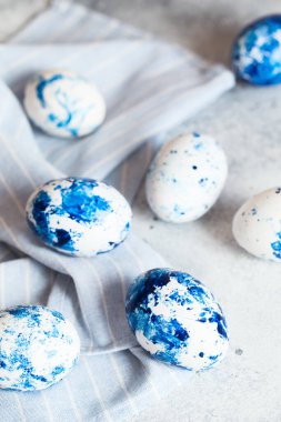 Boyalı Paskalya yumurtaları. Gri arka planda klasik mavi 2020 Paskalya yumurtası. Boya ve fırçalı mavi benekli paskalya yumurtaları. Yumurta süslüyor, Paskalya için hazırlanıyor.