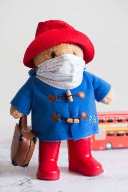 Londra, İngiltere - 25 Mart 2020: Coronavirus Salgını. Londra 'da karantina. Tıbbi maskeli Paddington yumuşak oyuncağı. Coronavirus Kontrolü