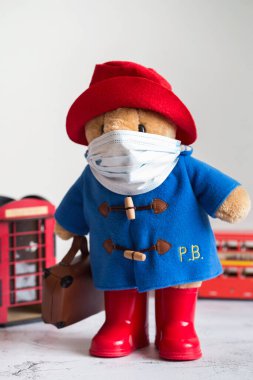 Londra, İngiltere - 25 Mart 2020: Coronavirus Salgını. Londra 'da karantina. Tıbbi maskeli Paddington yumuşak oyuncağı. Coronavirus Kontrolü