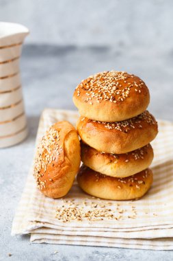 Kahvaltıda birkaç taze susamlı çörek. Tahtada susamlı çörekler..