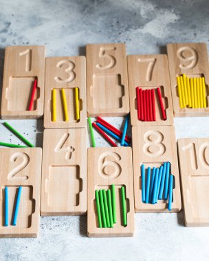 Tahta sayma ve renkli sayma çubuklarıyla tepsiler yazma. Montessori malzemeleri. Matematik oyunu da dahil. Doğal ahşaptan yapılmış çocuk oyuncakları..