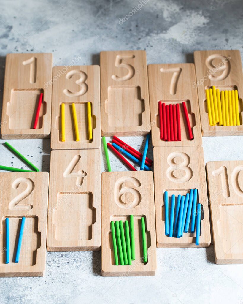 Wooden counting and writing trays with colored counting sticks. Montessori materials. Counting math play game. Children's toys made of natural wood.