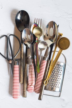 Beyaz arka planda klasik çatal bıçak takımı. Siyah ve beyaz gümüş kaşıklar, çatallar, masa bıçakları, makas ve ızgaralar..
