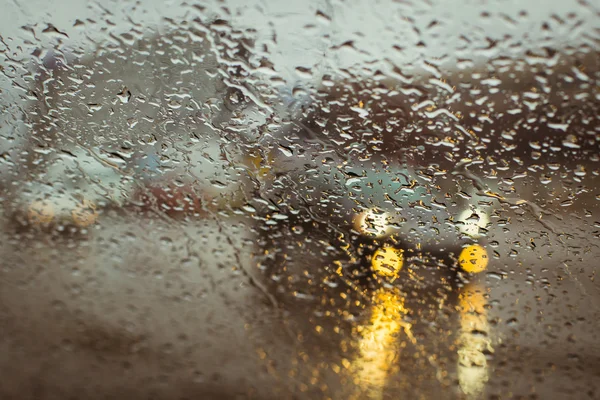 水滴を通して見たぼやけて車シルエット — ストック写真