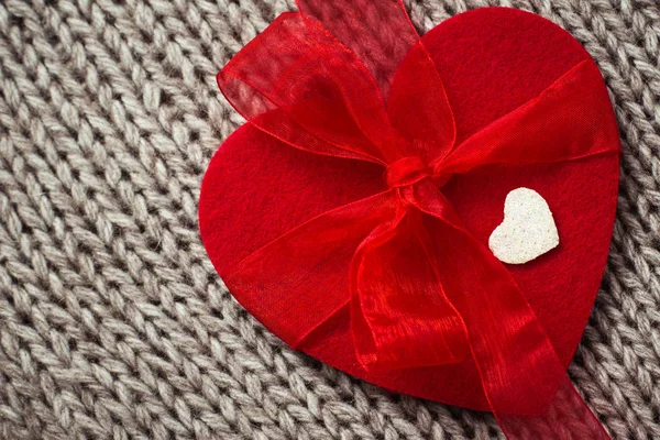 Cuore di feltro rosso e un piccolo cuore decorativo bianco — Foto Stock