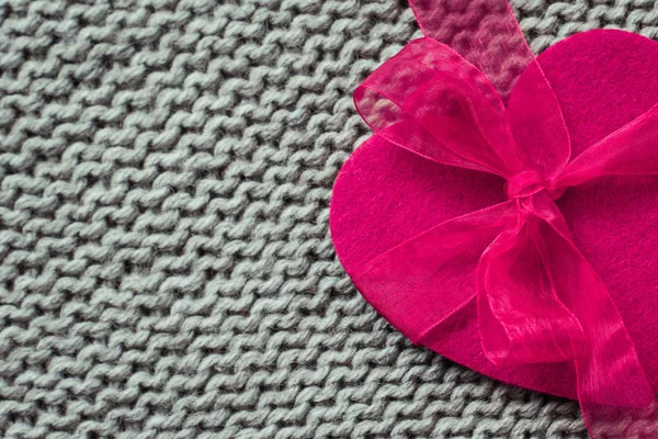 Cuore in feltro rosa con trama in lana lavorata a maglia come sfondo — Foto Stock