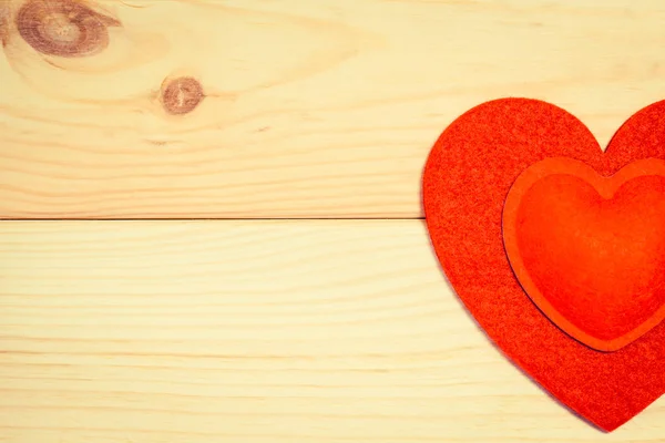 Cuori di feltro rosso su uno sfondo di legno — Foto Stock